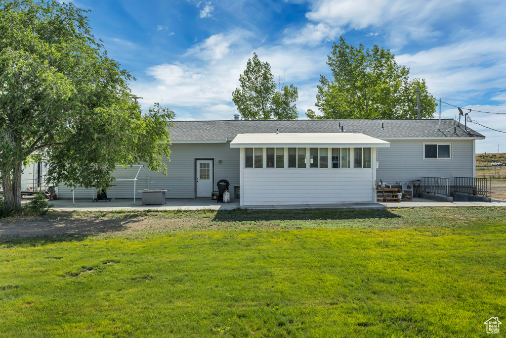 Rear view of house with a patio and a shingled roof