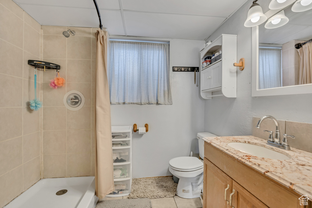 Full bathroom featuring vanity, tiled shower, and tile patterned floors