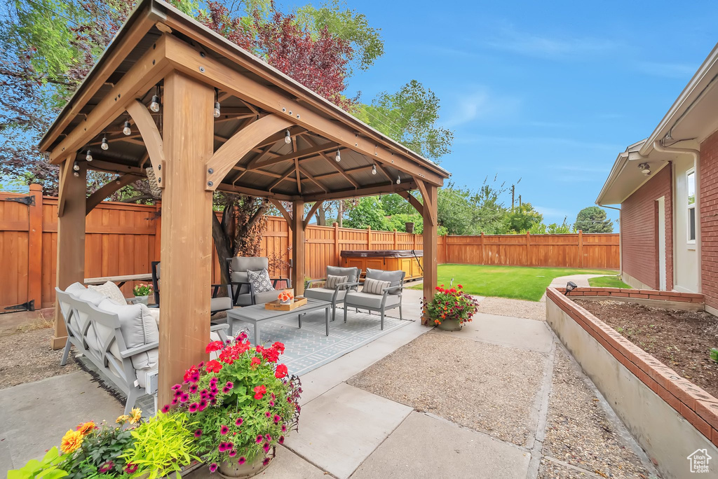 Fenced backyard featuring an outdoor hangout area, a gazebo, and a patio