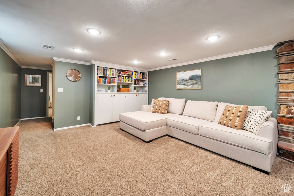 Carpeted living area with crown molding and recessed lighting