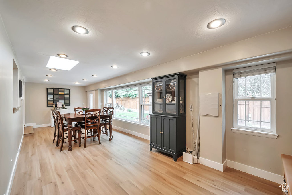 Dining space with light wood-type flooring, a skylight, and recessed lighting