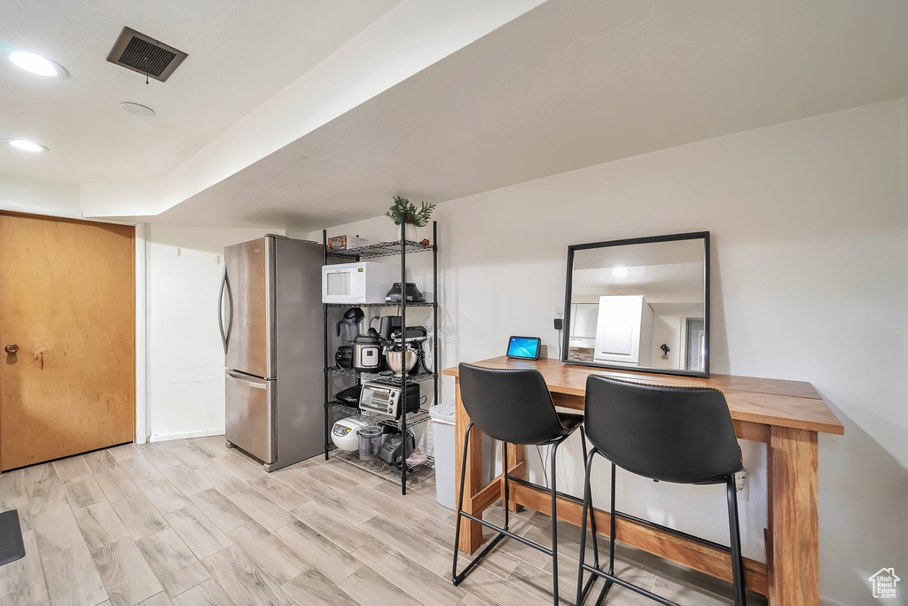 Office space with light wood finished floors and recessed lighting