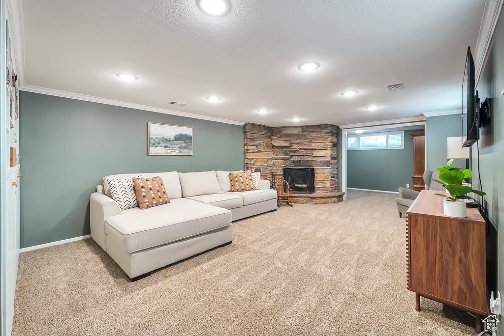 Living area featuring ornamental molding, light colored carpet, a fireplace, and recessed lighting