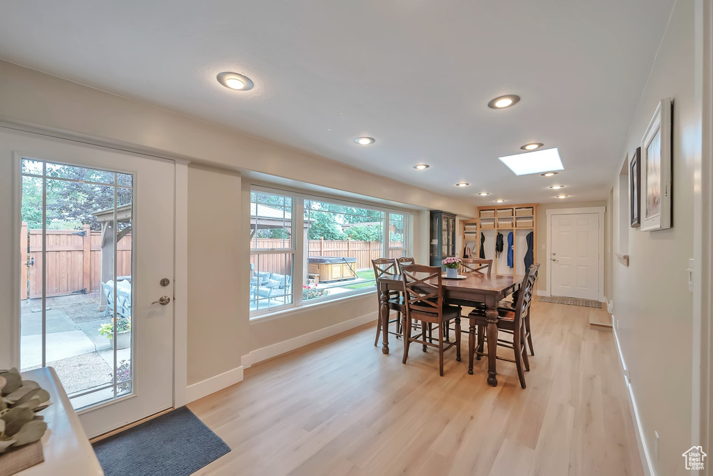 Dining space with light wood finished floors, recessed lighting, and a skylight