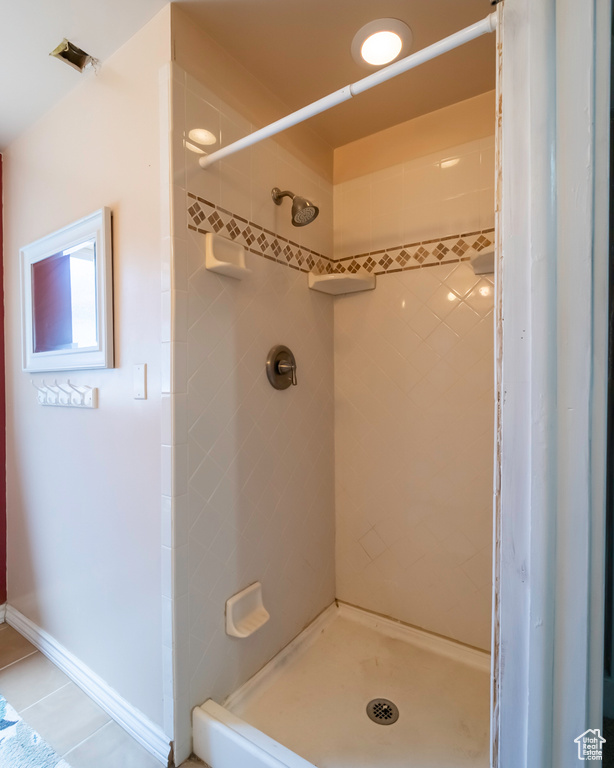 Bathroom with a stall shower and tile patterned floors