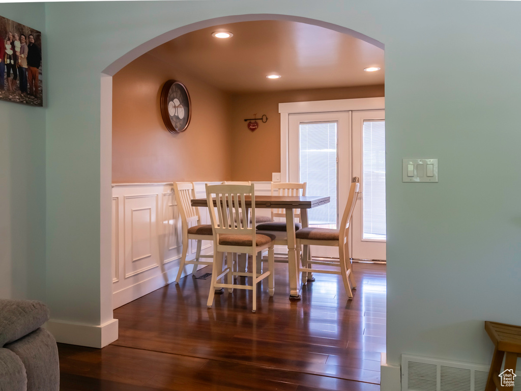 Dining space featuring arched walkways, dark wood-type flooring, recessed lighting, and french doors
