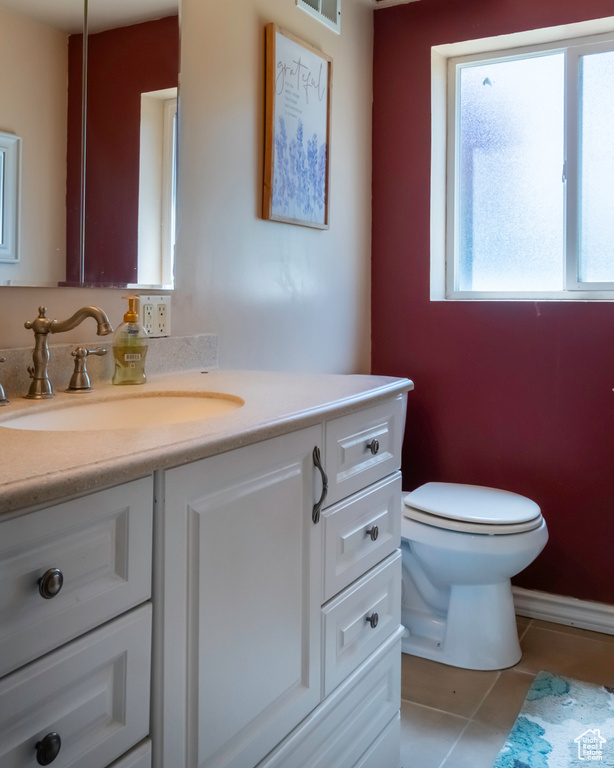 Half bathroom featuring vanity and tile patterned flooring