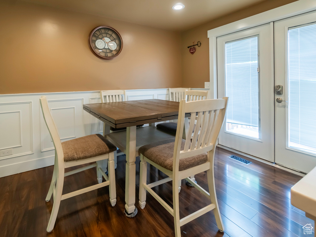 Dining room with a decorative wall, french doors, wood finished floors, a wainscoted wall, and recessed lighting