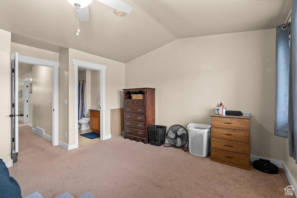 Carpeted bedroom featuring lofted ceiling and ensuite bathroom