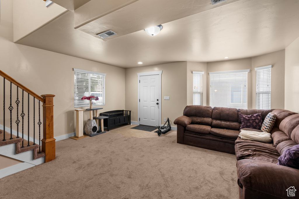 Living room featuring carpet flooring, plenty of natural light, stairs, and recessed lighting