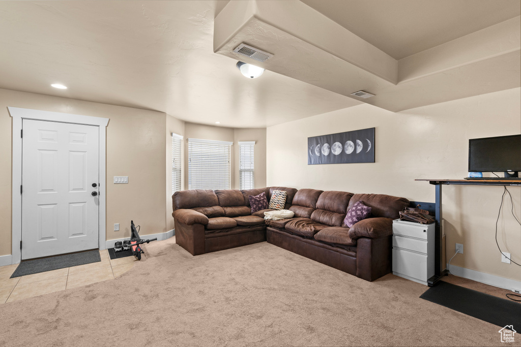 Carpeted living area with tile patterned floors and recessed lighting