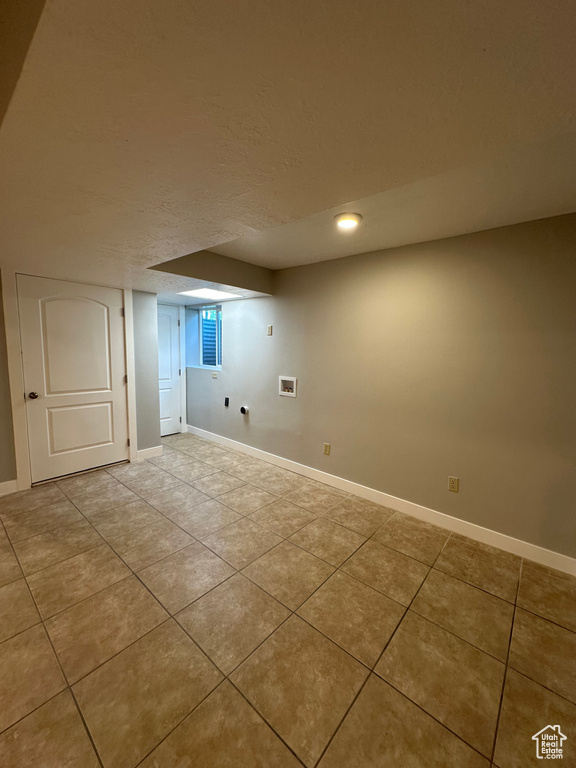 Finished below grade area featuring tile patterned flooring, recessed lighting, and a textured ceiling