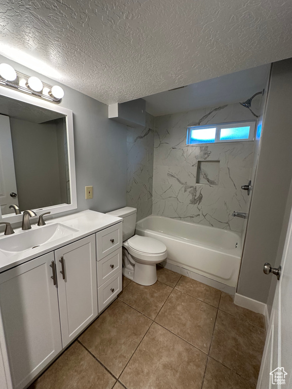 Bathroom with vanity, a textured ceiling, shower / tub combination, and tile patterned flooring