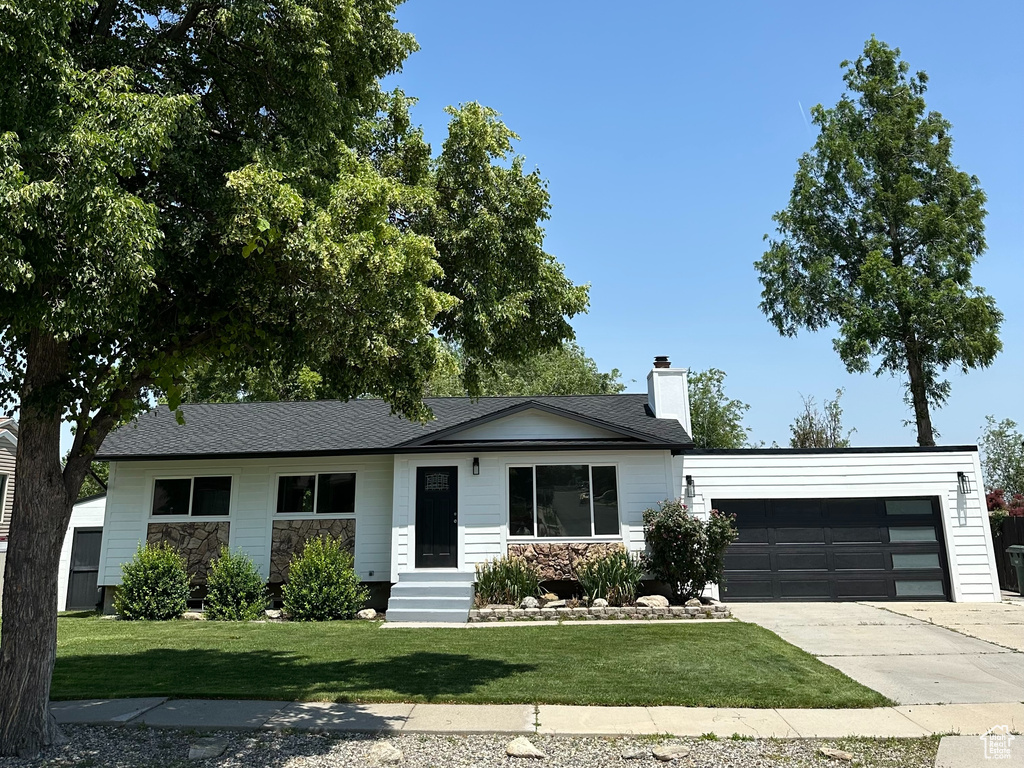 Ranch-style house with a garage, concrete driveway, a front yard, a chimney, and entry steps