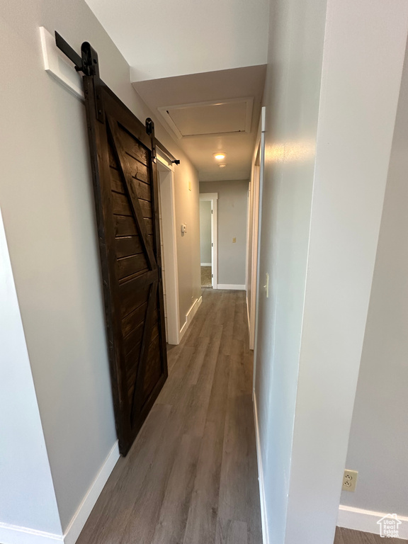 Hallway with a barn door and light wood-style floors