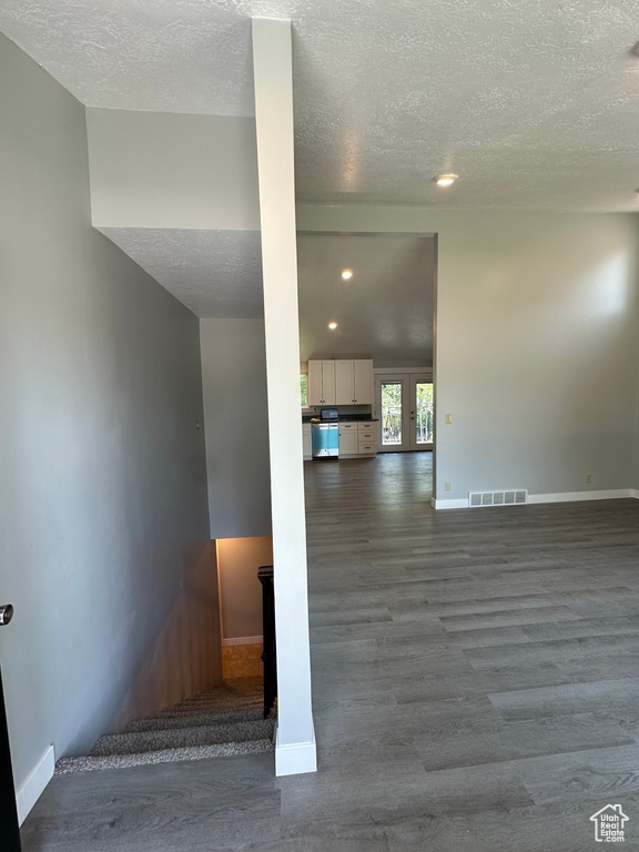 Stairway featuring a textured ceiling, wood finished floors, and recessed lighting