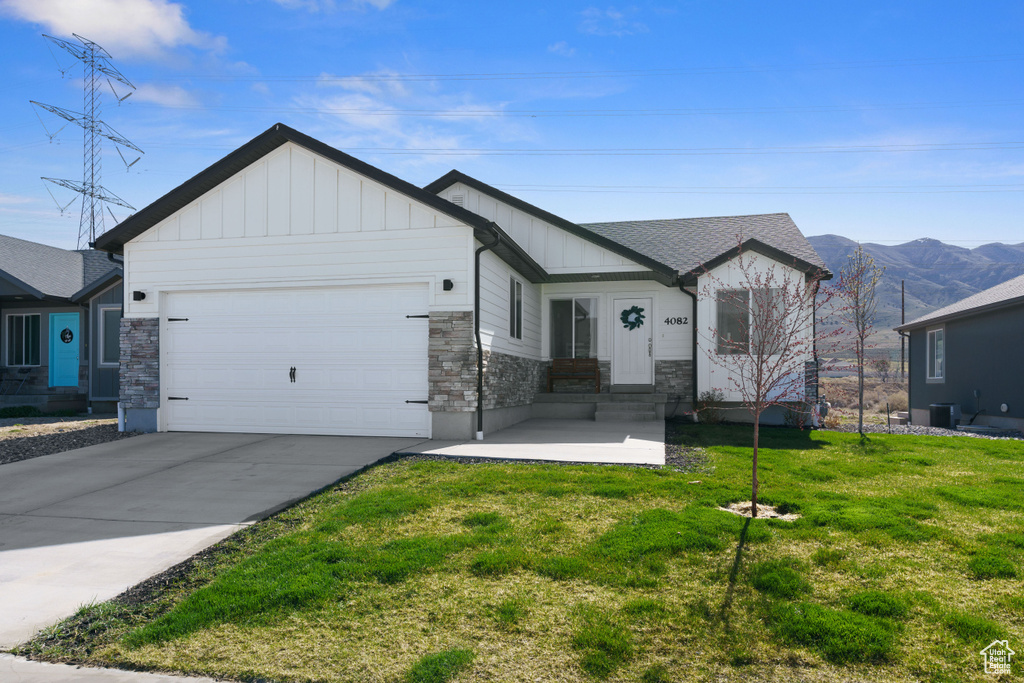 View of front of home featuring entry steps, board and batten siding, stone siding, and an attached garage