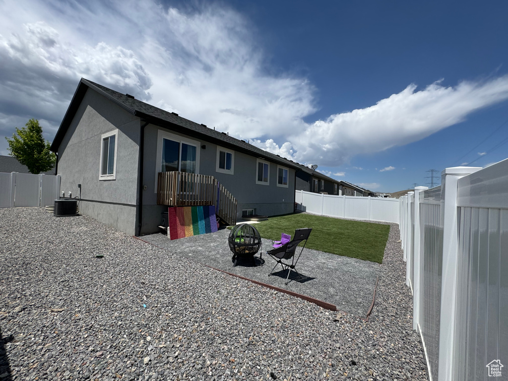 Back of house featuring a fire pit and stucco siding