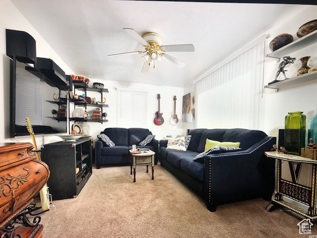 Carpeted living area with ceiling fan