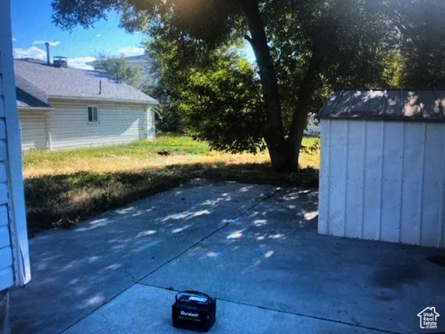 View of patio featuring a storage unit