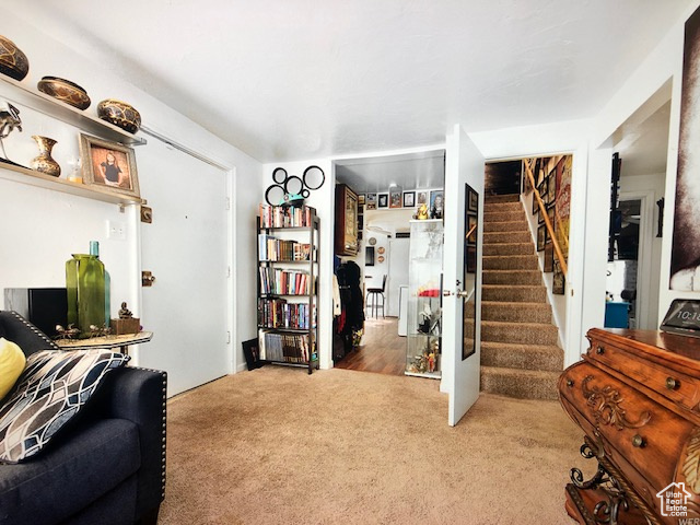 Carpeted living area featuring stairs
