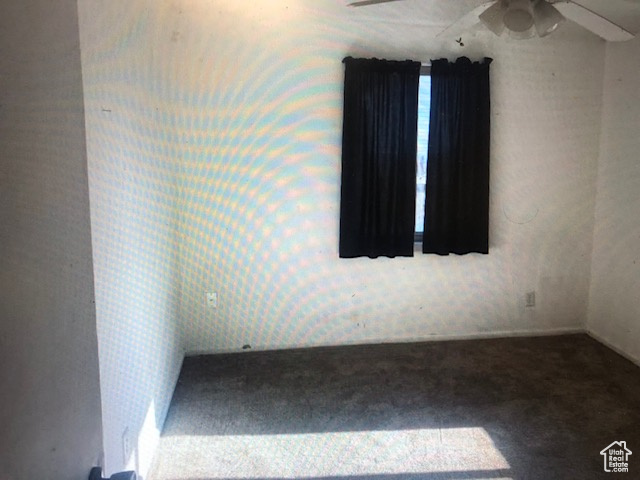 Carpeted empty room featuring ceiling fan