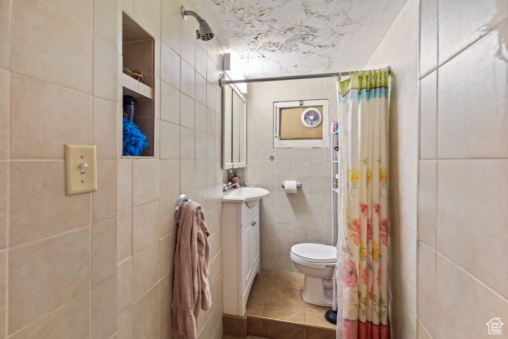 Bathroom featuring tile walls, tile patterned floors, vanity, and curtained shower