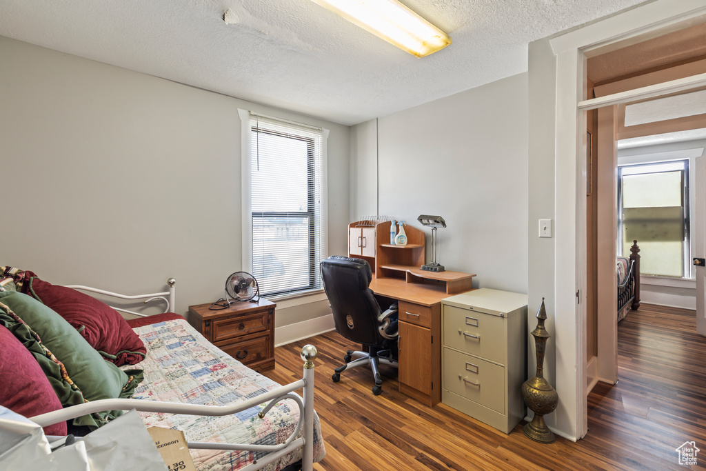 Office space with a textured ceiling and wood finished floors