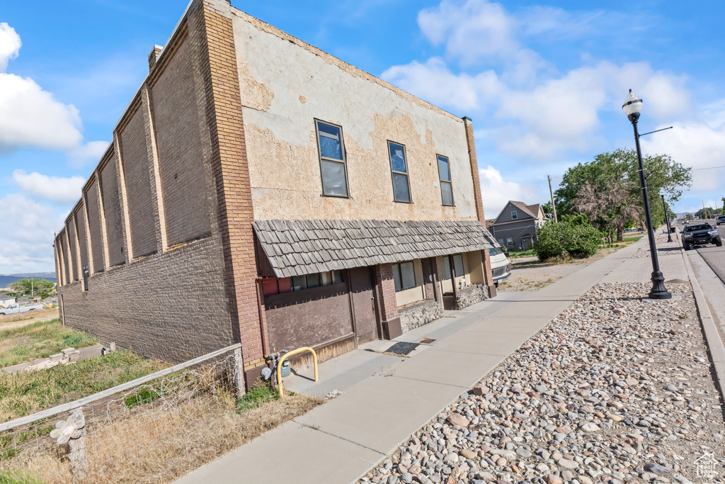 View of side of home featuring brick siding and stucco siding