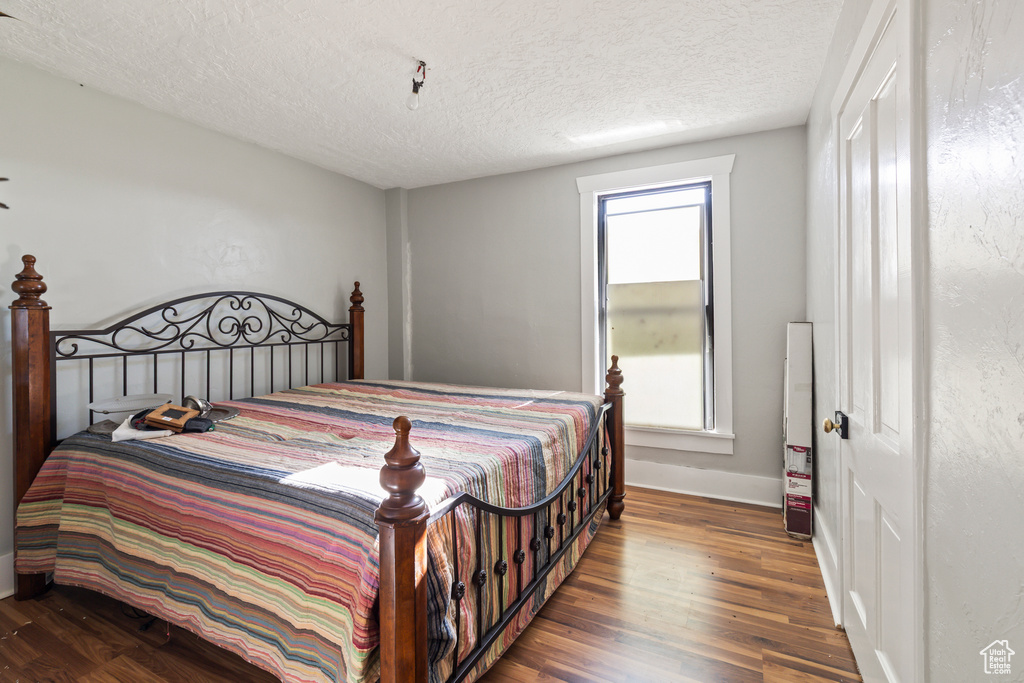 Bedroom featuring wood finished floors and a textured ceiling