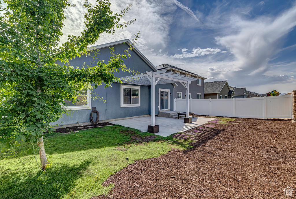Rear view of house featuring a pergola, a patio, and stucco siding