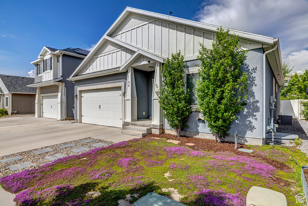 View of front of home featuring concrete driveway, board and batten siding, and an attached garage