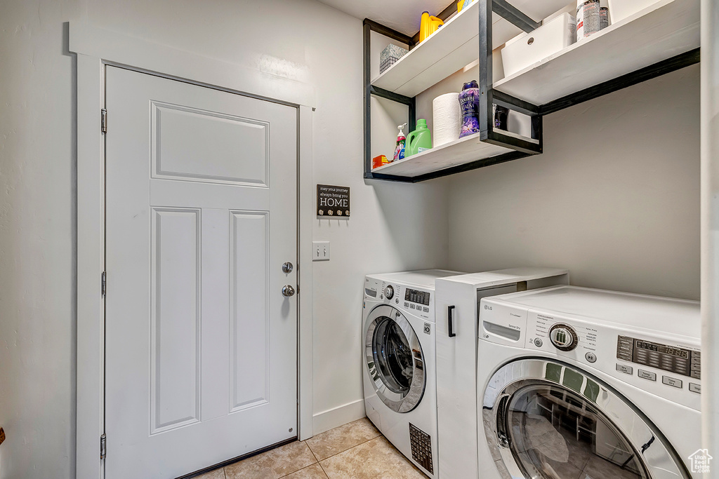 Laundry area with washing machine and dryer and light tile patterned floors
