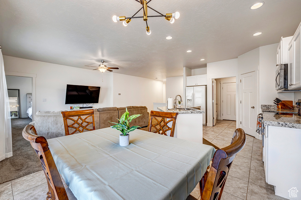 Dining space with a ceiling fan, recessed lighting, light tile patterned floors, and a chandelier
