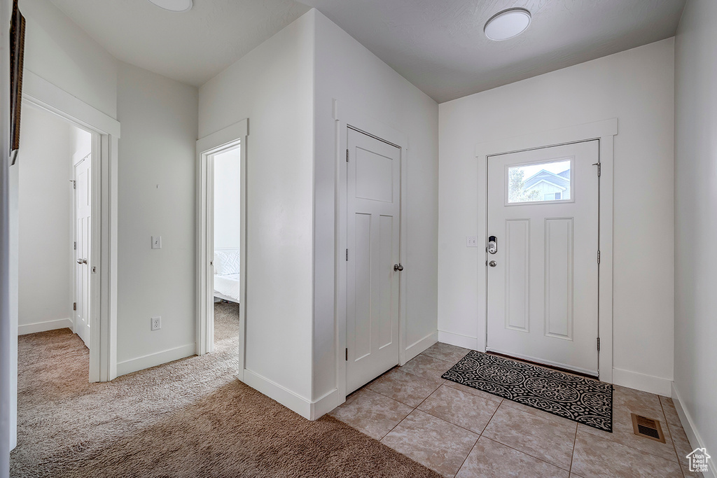 Foyer entrance featuring baseboards and light tile patterned flooring