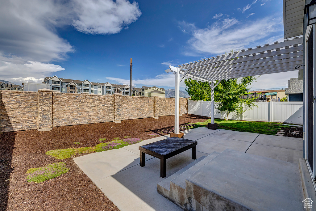 Fenced backyard featuring a pergola, a patio, and a residential view
