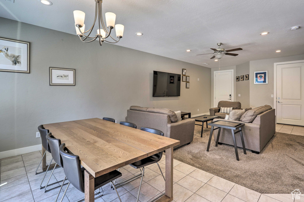 Dining space featuring recessed lighting, light tile patterned floors, a ceiling fan, a chandelier, and baseboards