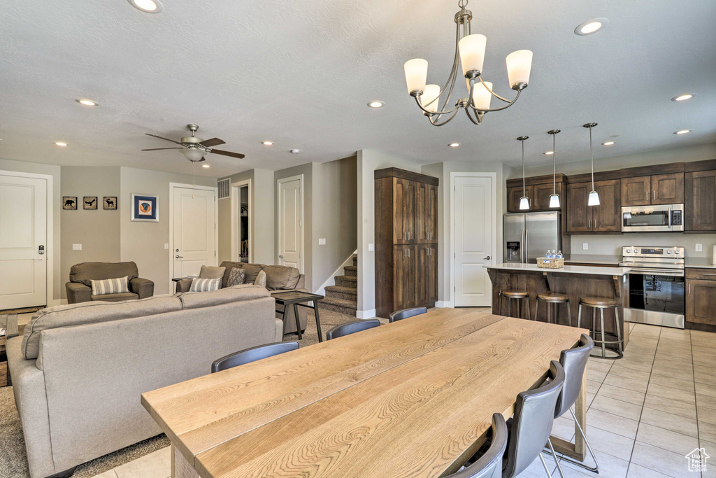 Dining room featuring recessed lighting, light tile patterned floors, a chandelier, stairway, and ceiling fan