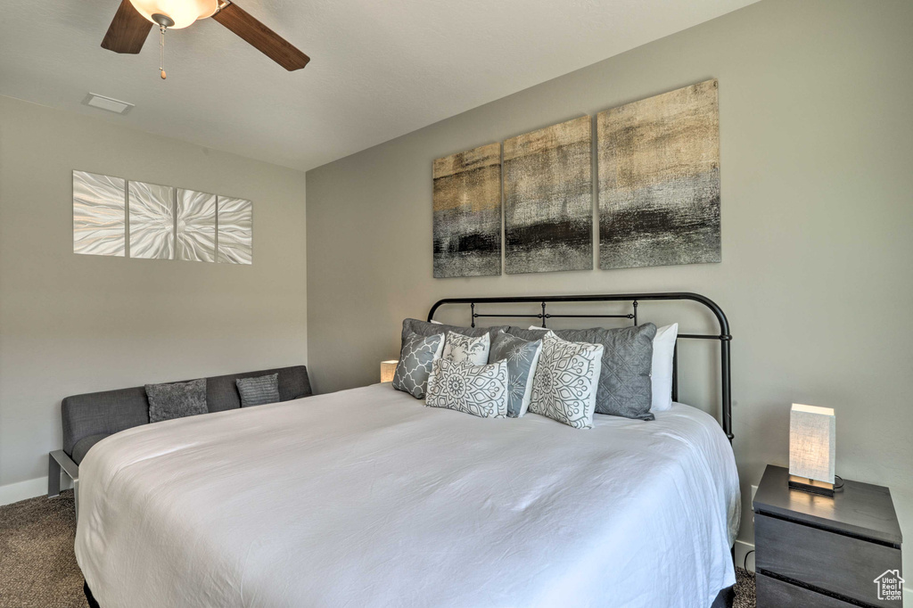 Carpeted bedroom with baseboards and a ceiling fan