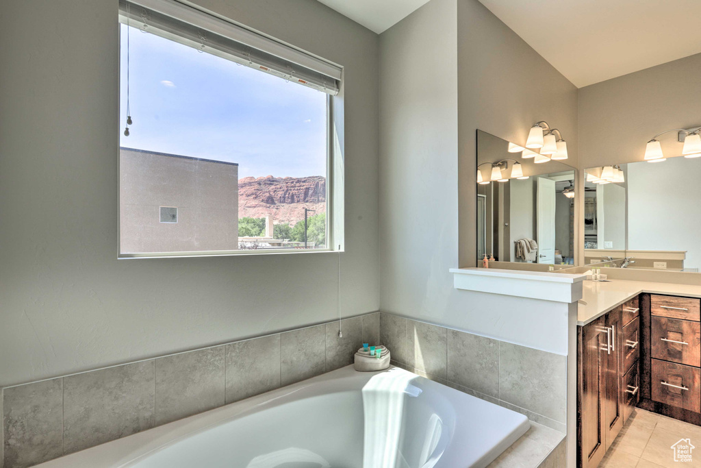 Bathroom with vanity, a bath, a mountain view, and tile patterned floors