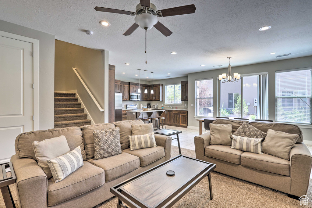 Living area featuring recessed lighting, a chandelier, stairs, a ceiling fan, and baseboards