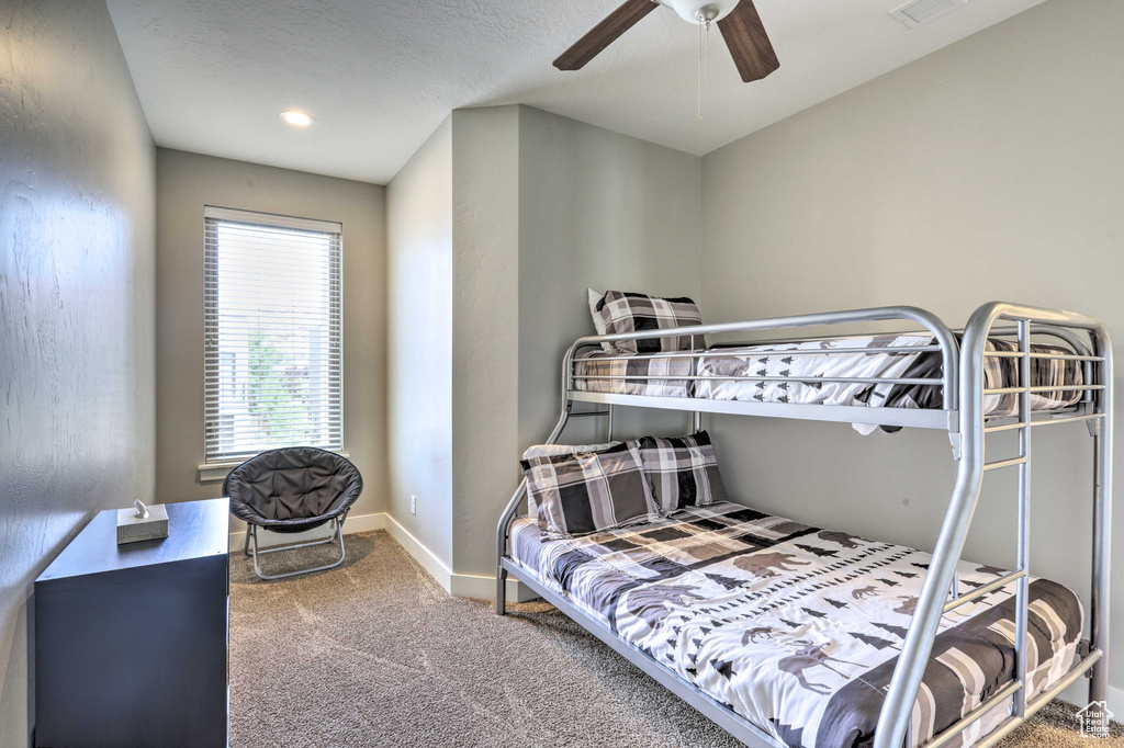 Bedroom featuring carpet floors, baseboards, and a ceiling fan
