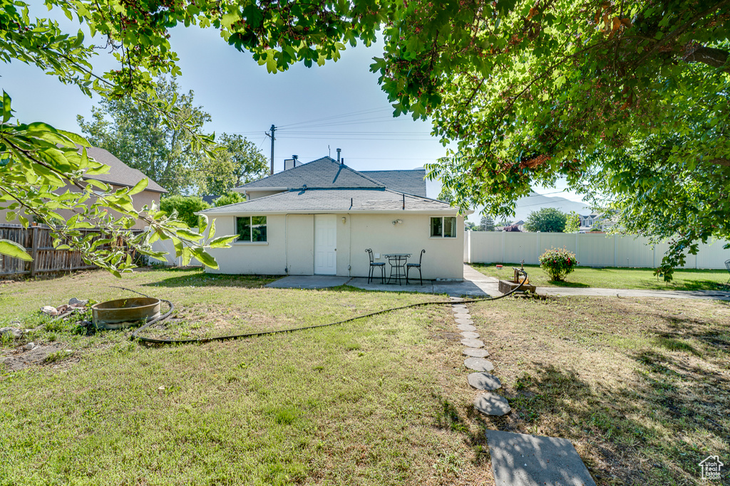 Back of house featuring a fenced backyard, a patio area, and stucco siding
