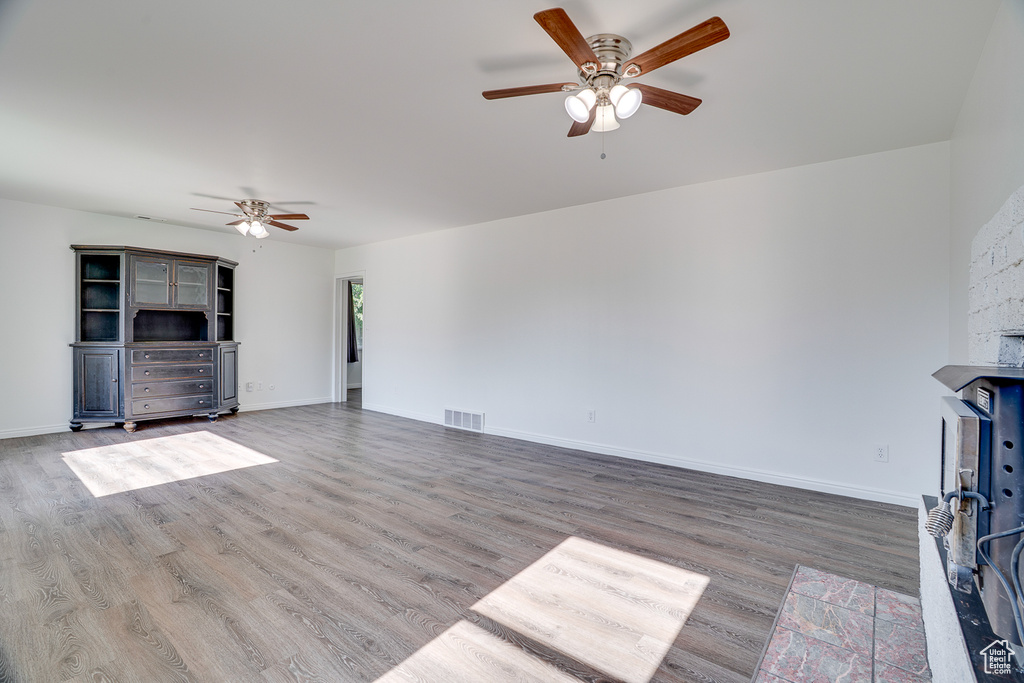Unfurnished living room with a ceiling fan and wood finished floors