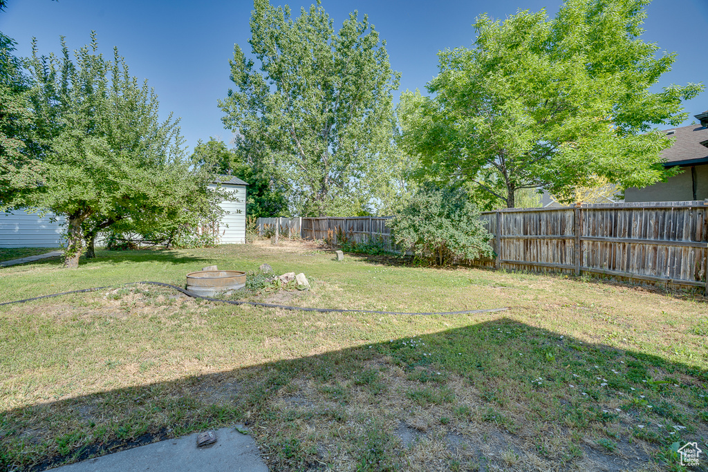 Fenced backyard featuring a storage shed