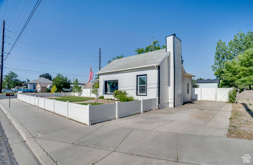 Bungalow-style house featuring a gate, a chimney, and concrete driveway