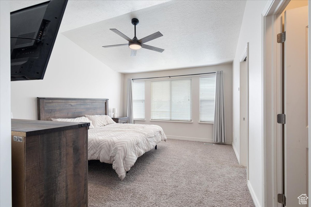 Bedroom with carpet, vaulted ceiling, and a ceiling fan