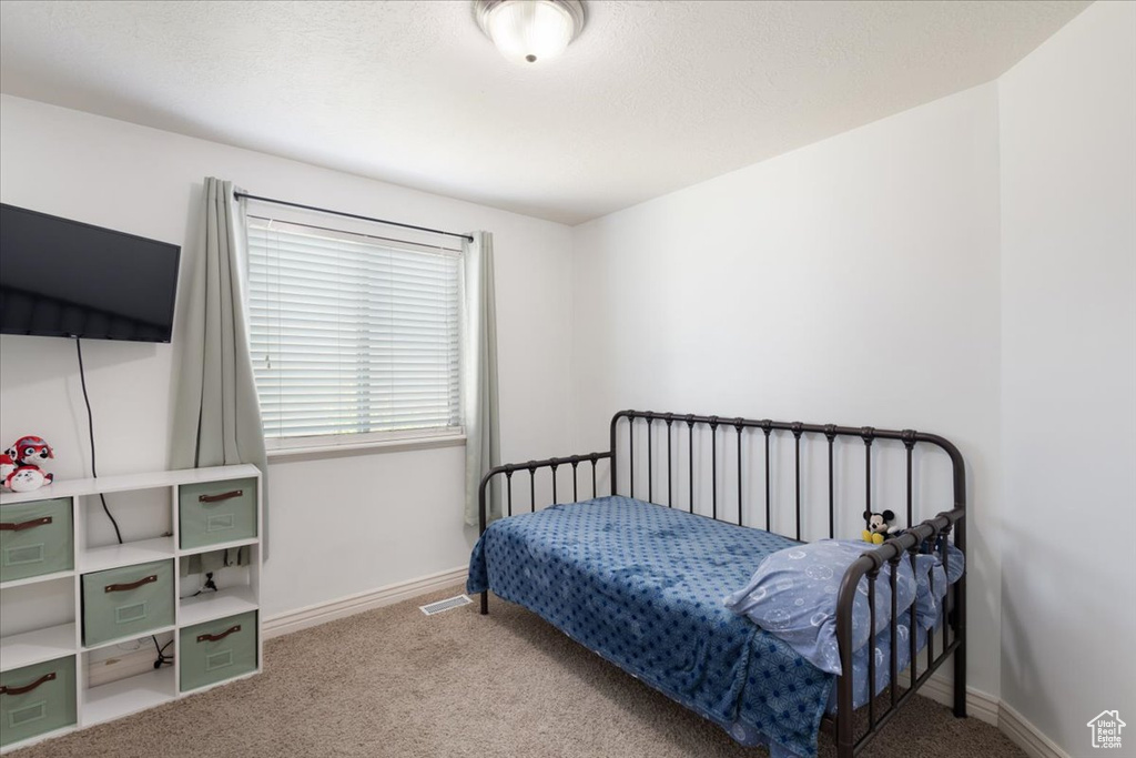 Carpeted bedroom featuring baseboards