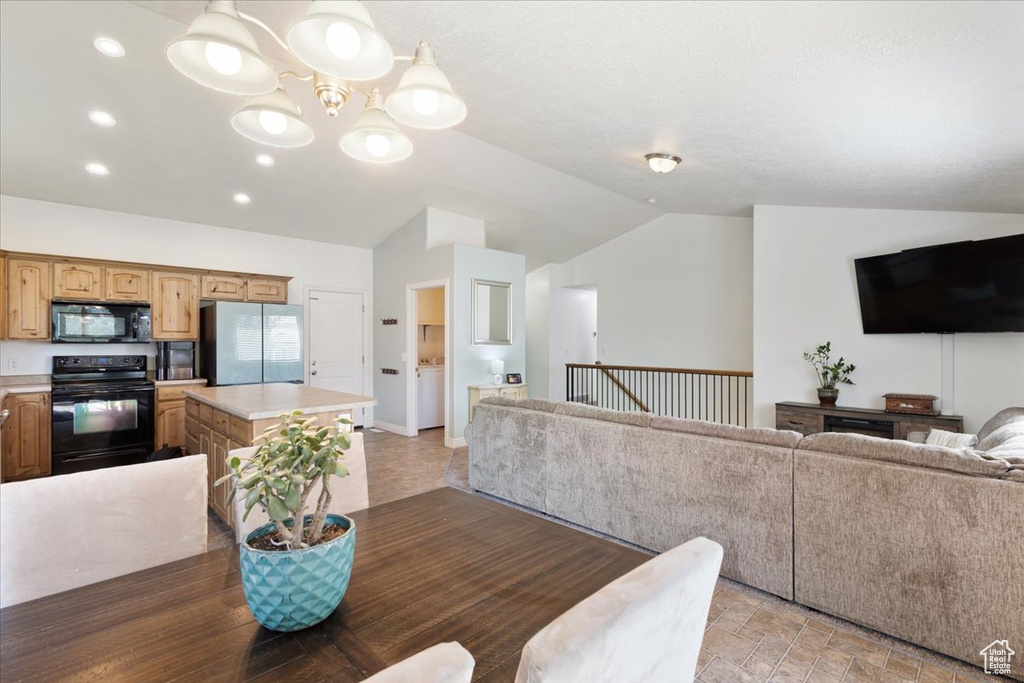 Dining room with vaulted ceiling, a chandelier, and recessed lighting