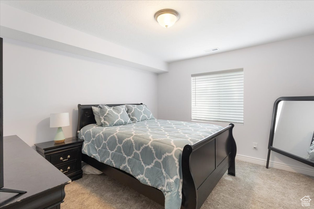 Bedroom with light carpet and baseboards